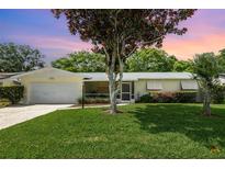 Charming home with a well-manicured lawn, attached garage, and a cozy screened in porch at 692 Gaslight Dr, South Daytona, FL 32119