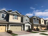 Charming townhomes featuring colorful siding, brick driveways, and attached garages in a well-maintained community at 1003 E 10 St, Apopka, FL 32703