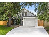 Charming home featuring grey siding, a one-car garage and mature trees for shade at 1358 Brookebridge Dr, Orlando, FL 32825
