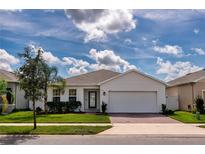 Charming single-story home with brick driveway, lush landscaping, and a two-car garage at 165 Lavenna Ave, St Cloud, FL 34771