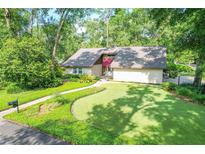 Charming home featuring a well-manicured lawn, mature trees, and a brick pathway leading to the front door at 264 Agnes Ave, Longwood, FL 32750