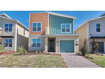 Charming two-story home with colorful exterior, one car garage and neatly landscaped front yard at 2665 Petition Ln, Kissimmee, FL 34746