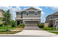 Charming two-story home with a well-maintained lawn and an attached two-car garage at 2817 Muller Oak Loop, Ocoee, FL 34761