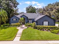 Beautifully landscaped front yard with lush lawn, mature trees, and elegant walkway to the home's entrance at 315 Lake Rd, Lake Mary, FL 32746