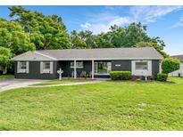 Charming single story home featuring a manicured lawn, mature trees, and a welcoming front porch at 3417 Pershing Ave, Orlando, FL 32812