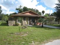 Charming stone-clad single-story home with a well-maintained lawn and mature landscaping at 3700 Washington St, Sanford, FL 32771