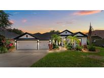 Charming home with a well-manicured lawn, lush landscaping, and a three-car garage at 533 Quail Down Dr, Debary, FL 32713