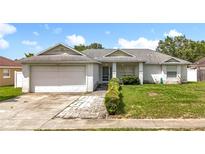 Charming single-story home with a well-maintained front yard and attached two-car garage at 5409 Holtland Dr, Apopka, FL 32712