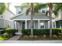 Charming home with well-manicured landscaping and inviting front porch framed by beautiful palm trees at 5963 Glory Bower Dr, Winter Garden, FL 34787
