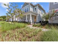 Charming two-story home with inviting front porch and beautifully landscaped yard and black metal fence at 923 Colie Aly, Winter Garden, FL 34787