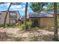 Townhouse exterior showcasing neutral stucco, dark roof, and mature landscaping at 940 Douglas Ave # 159, Altamonte Springs, FL 32714