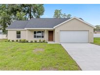 Charming single-story home featuring a two-car garage, well-maintained lawn, and neutral color palette at 1059 Ne 130Th Ter, Silver Springs, FL 34488