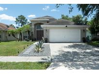 Charming home with a manicured lawn, complemented by palm trees and tasteful landscaping at 11761 Hatcher Cir, Orlando, FL 32824