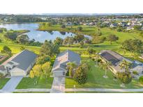 Stunning aerial view of home and lake, showcasing a well-manicured lawn and beautiful surrounding neighborhood at 1315 Vista Del Lago Blvd, Dundee, FL 33838