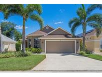 Inviting single-story home featuring lush landscaping, a two-car garage, and a well-maintained lawn at 144 Bridgeton St, Davenport, FL 33896