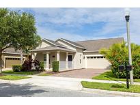 Charming single Gathering home featuring a well-manicured lawn and a brick driveway leading to an attached two-car garage at 14845 Speer Lake Dr, Winter Garden, FL 34787