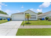 Charming single-story home with a well-manicured lawn, light-colored exterior, and attached garage at 2110 Mallard Creek Cir, Kissimmee, FL 34743