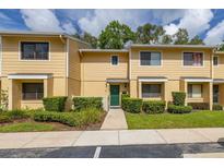 Charming townhouse with manicured landscaping, a green front door, and ample natural light at 2208 Mcmahon Ct # 1033, Orlando, FL 32812