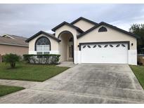 Charming single Gathering home featuring neutral paint, an arched doorway, and manicured landscaping at 2505 Osprey Creek Ct, Kissimmee, FL 34747