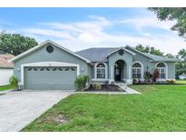 Charming single-story home featuring manicured lawn, two-car garage, and an inviting arched entryway at 2675 Bond St, Clermont, FL 34711