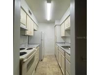 Functional kitchen features tile floors, stainless steel sink, and white cabinets for a clean, classic look at 415 Wymore Rd # 101, Altamonte Springs, FL 32714