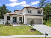 Beautiful two-story home featuring a landscaped front yard, a neutral color palette, and a two-car garage at 523 Sanctuary Golf Pl, Apopka, FL 32712