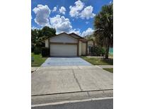 Charming single-story home featuring a spacious driveway, two-car garage, and a well-maintained front yard with mature trees at 5396 Lonesome Dove Dr, Kissimmee, FL 34746