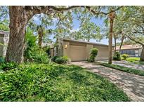 Charming home featuring a two-car garage and lush landscaping surrounded by mature trees at 616 Woodridge Dr, Casselberry, FL 32730
