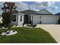 Well-maintained single-story home featuring a manicured lawn and tidy landscaping and a two car garage at 862 Bowden Rd, Wildwood, FL 34785