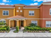 Inviting townhouse with a red tile roof and well-maintained landscaping at 8977 Majesty Palm Rd, Kissimmee, FL 34747