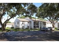 Two-story condo building with ample parking and mature shade trees surrounding the property at 954 Courtyard Ln # 52, Orlando, FL 32825