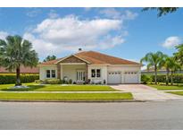 Charming single-story home with a well-manicured lawn, stone accents, and a three-car garage at 9821 Caroline Park Dr, Orlando, FL 32832