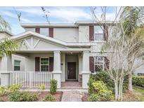 Charming two-story home with a well-manicured lawn and inviting front porch featuring brown shutters at 11139 Cyrilla Woods Dr, Orlando, FL 32832