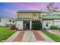 Charming townhome with a green tile roof, brick-lined driveway, and lush front yard at 1301 Winter Green Way, Winter Garden, FL 34787