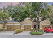 Inviting townhome exterior showcasing a well-manicured lawn and a charming two-car garage at 14242 Desert Haven St # Ge, Windermere, FL 34786