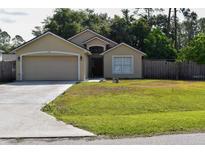 Inviting single-story home featuring a well-maintained lawn and attached two-car garage at 1436 Swan Ct, Kissimmee, FL 34759