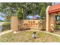 Attractive signage for Oak Shadows Condominiums with brick and stucco construction and mature landscaping at 2850 N Powers Dr # 74, Orlando, FL 32818