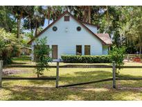 Charming light blue two-story home featuring a unique circular window design and a quaint fenced yard at 3580 Ne 160Th Ln, Citra, FL 32113
