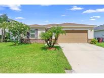 Charming single-story home featuring a lush green lawn and a two-car garage at 4529 Orchard Grove Rd, St Cloud, FL 34772