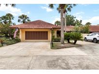 Charming single-story home featuring a terra cotta tile roof, attached garage, and meticulously landscaped front yard at 5057 Maui Cir # 15, Orlando, FL 32808