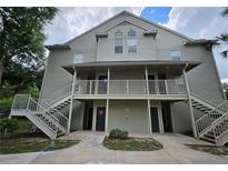 Two-story apartment building with gray siding, white trim, and elevated walkways at 5980 Westgate Dr Dr # 202, Orlando, FL 32835