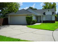 Charming single-story home with a well-manicured lawn, attached garage, and a curved driveway at 6500 Abercrombie Ct, Orlando, FL 32835