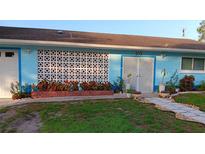 Charming single-story home with a baby blue exterior, mature landscaping, and a walkway leading to the front door at 833 Channing Rd, Lakeland, FL 33805