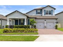Charming two-story home with brick-paved driveway, manicured landscaping, blue shutters and a two-car garage at 12216 Encore At Ovation Way, Winter Garden, FL 34787
