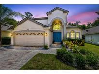 Stunning two-story home with a blue front door, lush landscaping, and a two-car garage at 1617 Song Sparrow Ct, Sanford, FL 32773