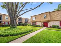 Attractive two-story condo building with lush lawn, mature trees and red front doors and shutters at 200 St Andrews Blvd # 601, Winter Park, FL 32792