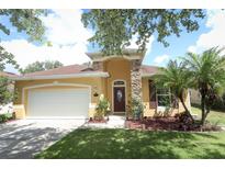 Charming one-story home featuring a stucco exterior, a stone column, and a well-manicured front lawn at 203 Brookgreen Way, Deland, FL 32724