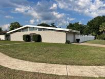 Charming single-story home with a stone facade, well-maintained lawn, and attached garage at 229 Doverwood Rd, Fern Park, FL 32730