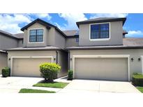 Modern townhome showcasing the attached garages and neutral paint colors on a sunny day at 2355 Seven Oaks Dr, St Cloud, FL 34772