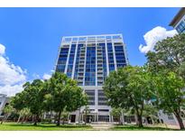 Modern building exterior with large windows, landscaped lawn, and vibrant blue sky at 260 S Osceola Ave # 902, Orlando, FL 32801